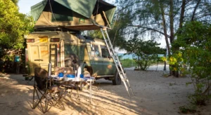 A green tent rests atop a truck, illustrating an adventurous camping experience related to uganda self drive cost.
