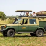 A safari masters vehicle with people on top, exploring the wildlife during a self drive Serengeti adventure.